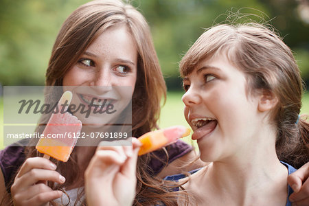 2 girls eating popsicles together