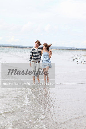 A  couple take a romantic beach stroll