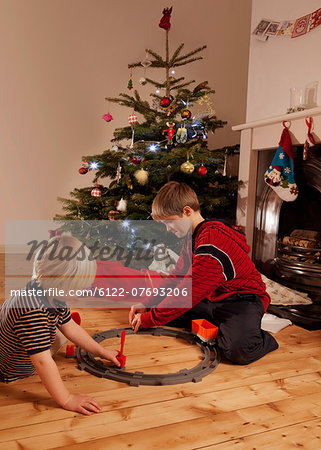 Two young boys playing with a train set