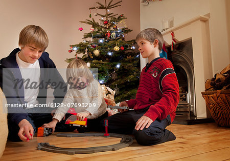 Three boys playing with a train set