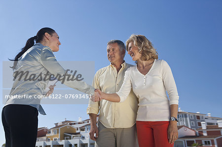 Realestate agent greeting mature couple