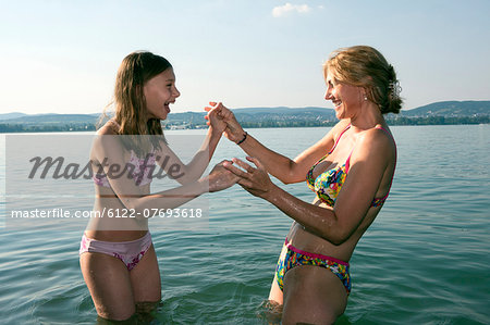 Mother and daughter playing in lake