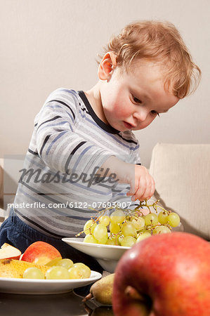 Little boy eating fruit