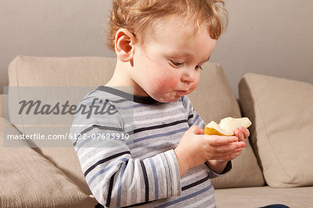 Little boy eating pear