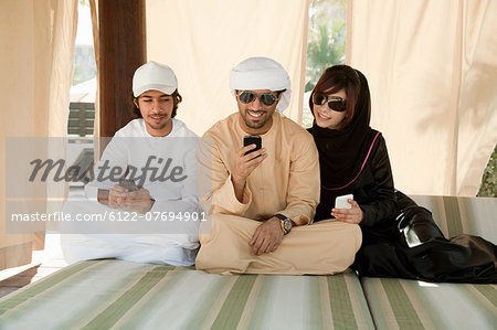 Middle Eastern people sitting on bed