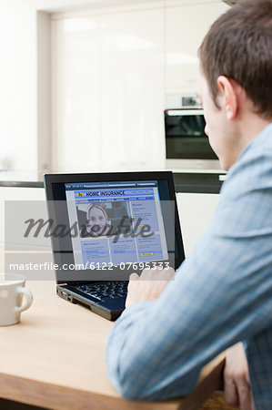 Young man looking at insurance on laptop