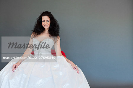 Young woman wearing white wedding dress, studio shot