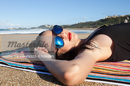 Woman lying on beach towel