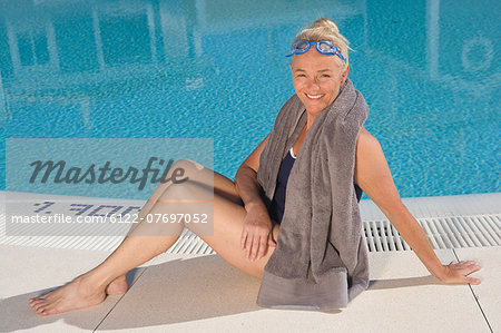 Mature woman sitting by swimming pool