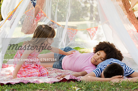 Three friends sleeping in summer netting tent