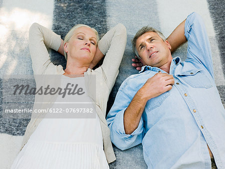 Couple lying on picnic blanket in garden