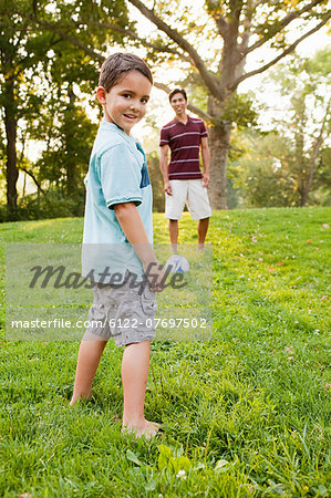 Boy in park with father, smiling