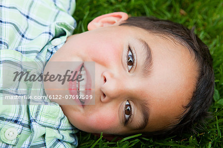 Boy smiling on grass, portrait