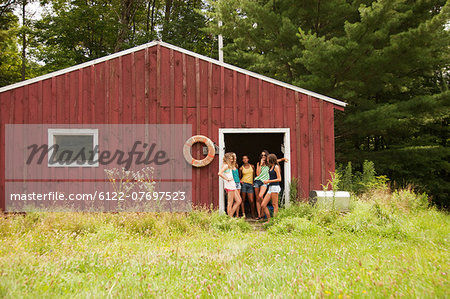 Teenage girls in door way of boat house during summer vacation