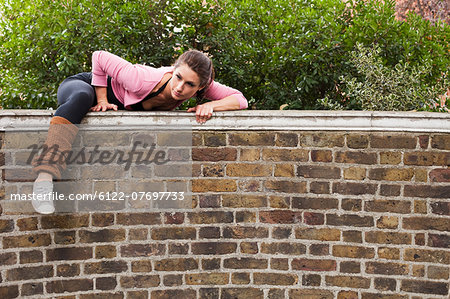 Woman climbing over over wall