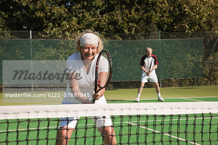 Senior and mature adults playing tennis