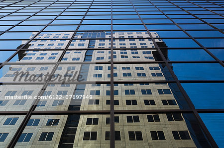 Building reflected in glass skyscraper