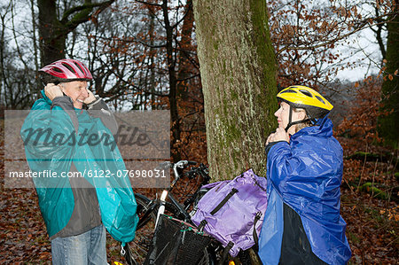 Senior couple preparing to cycle in forest