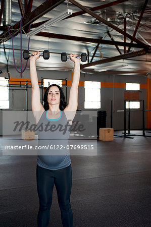 Pregnant young woman with hand weights