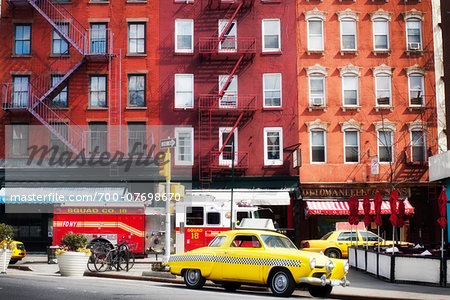 Traditional red brick buildings with old car and firetruck on street in the trendy Chelsea district, Manhattan, New York City, NY, USA