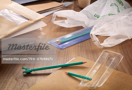 Close-up of envelopes, file folders, chewed pencils and plastic bag on office desk