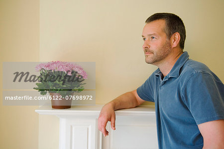Man leaning on mantle of new home