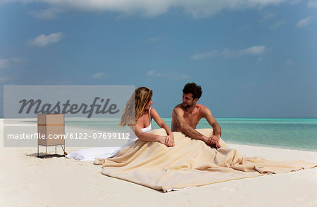 Couple sitting in bed on beach
