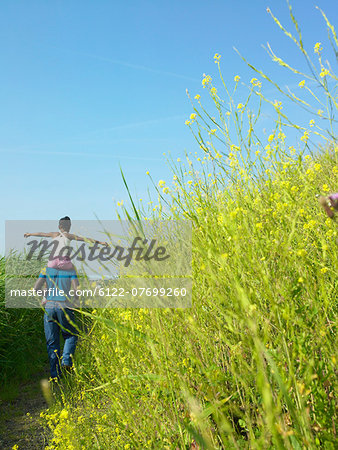 Daughter on father's shoulders in field