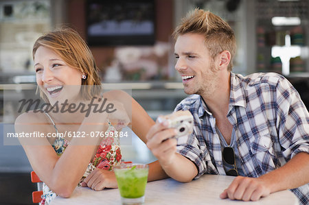 Couple admiring photos at cafe