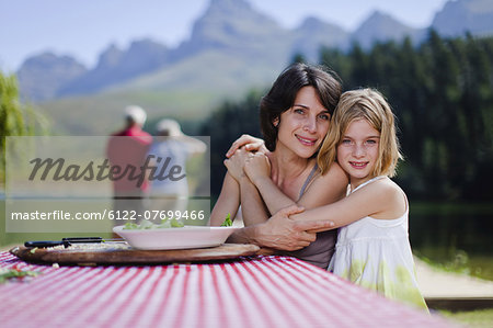 Mother and daughter hugging at picnic