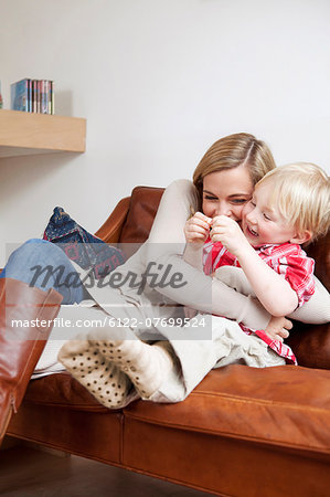 Mother and son hugging on sofa