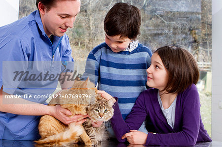 Vet talking to children with their cats
