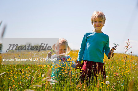 Children walking in field of flowers
