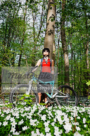 Mountain biker standing in forest