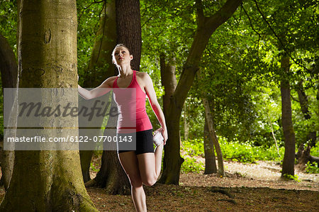 Jogger stretching in forest