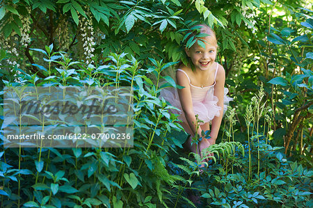 Girl in ballet costume hiding in bush