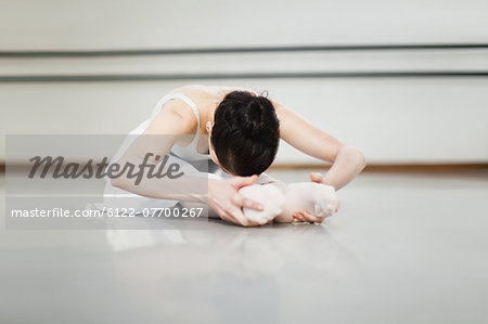 Ballet dancer stretching in studio