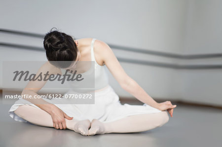 Ballet dancer stretching in studio