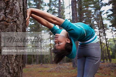 Runner stretching in forest