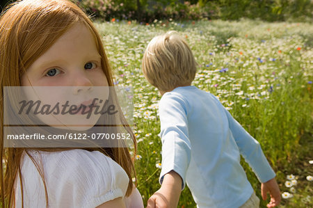 Children walking in field of flowers