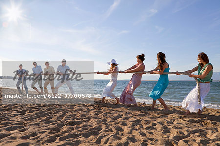 Newlyweds and guests playing tug of war