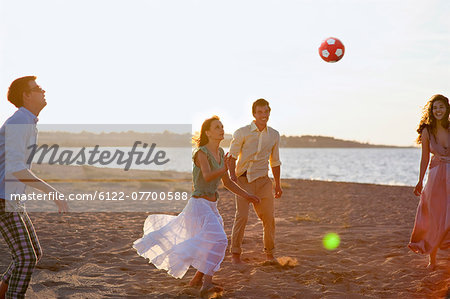 People playing with soccer ball on beach