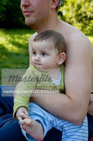 Father holding baby boy outdoors