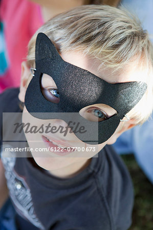 Close up of boy wearing cat mask