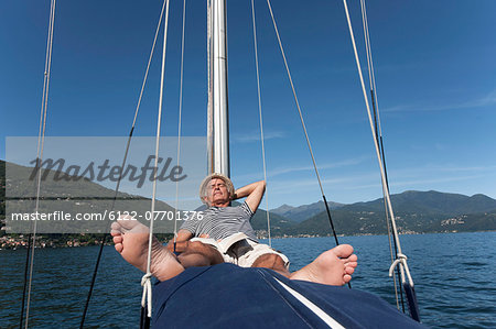 Older man relaxing on sailboat