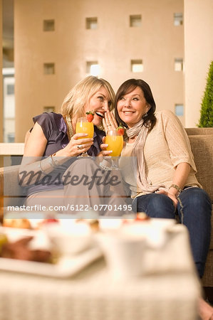 Women whispering over drinks