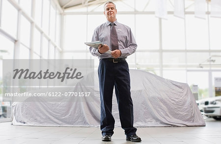 Car salesman standing in showroom
