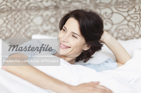 Smiling woman sitting up in bed