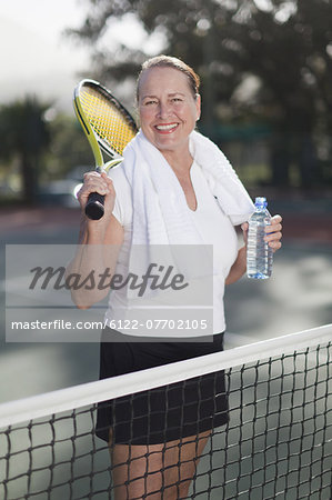 Older woman standing on tennis court