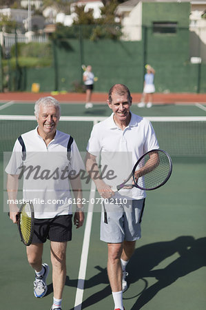 Older men walking on tennis court